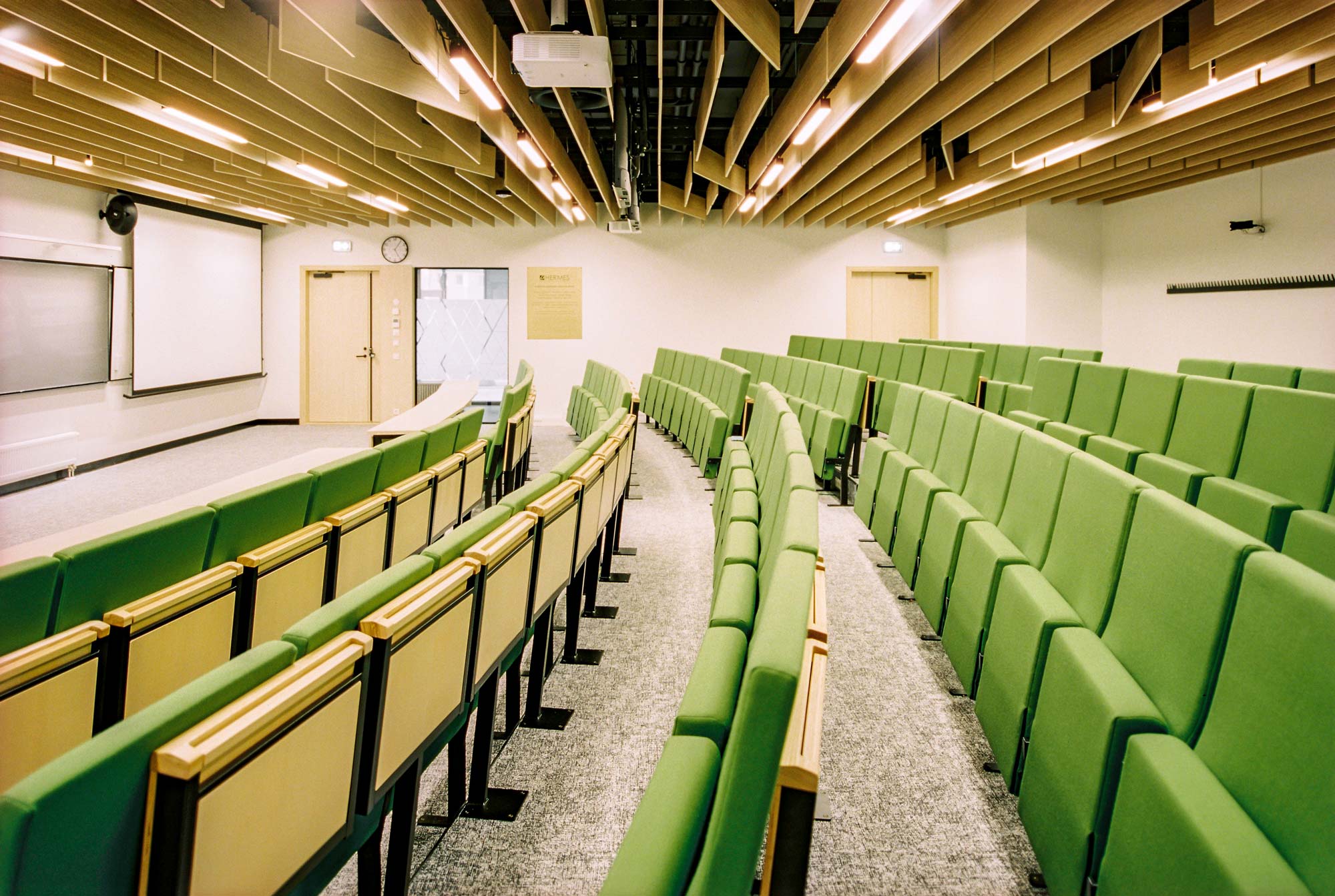Classroom with foldable green chairs and wooden ceiling