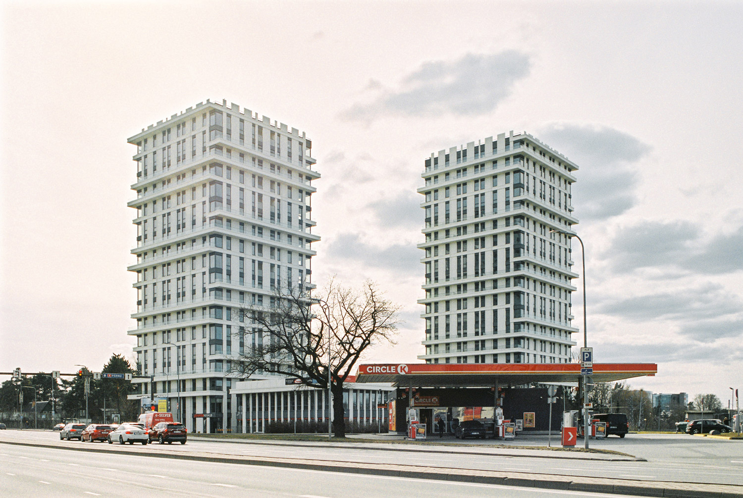 Modern architecture towers with Circle K gas station underneath