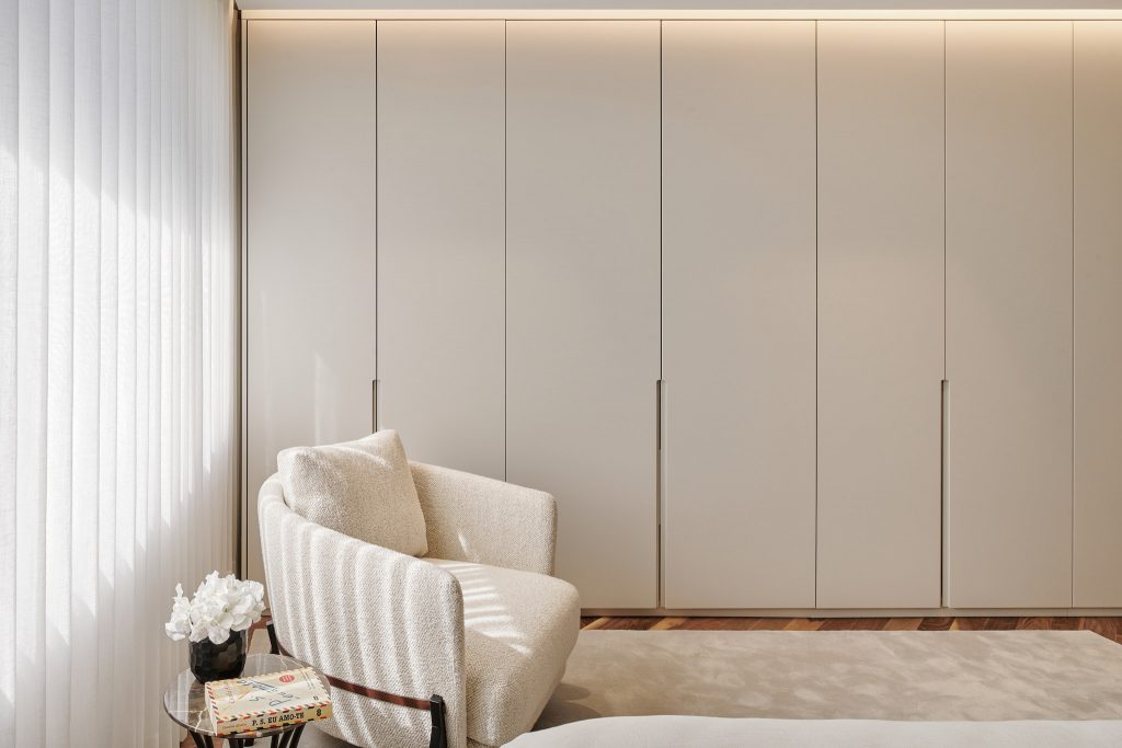 Bedroom with beige couch soft fabric white closet large window curtains