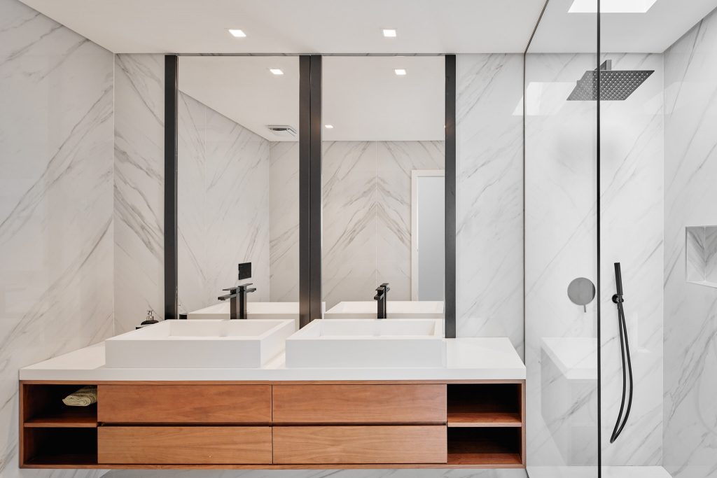 Minimalistic bathroom with glass shower and marble walls