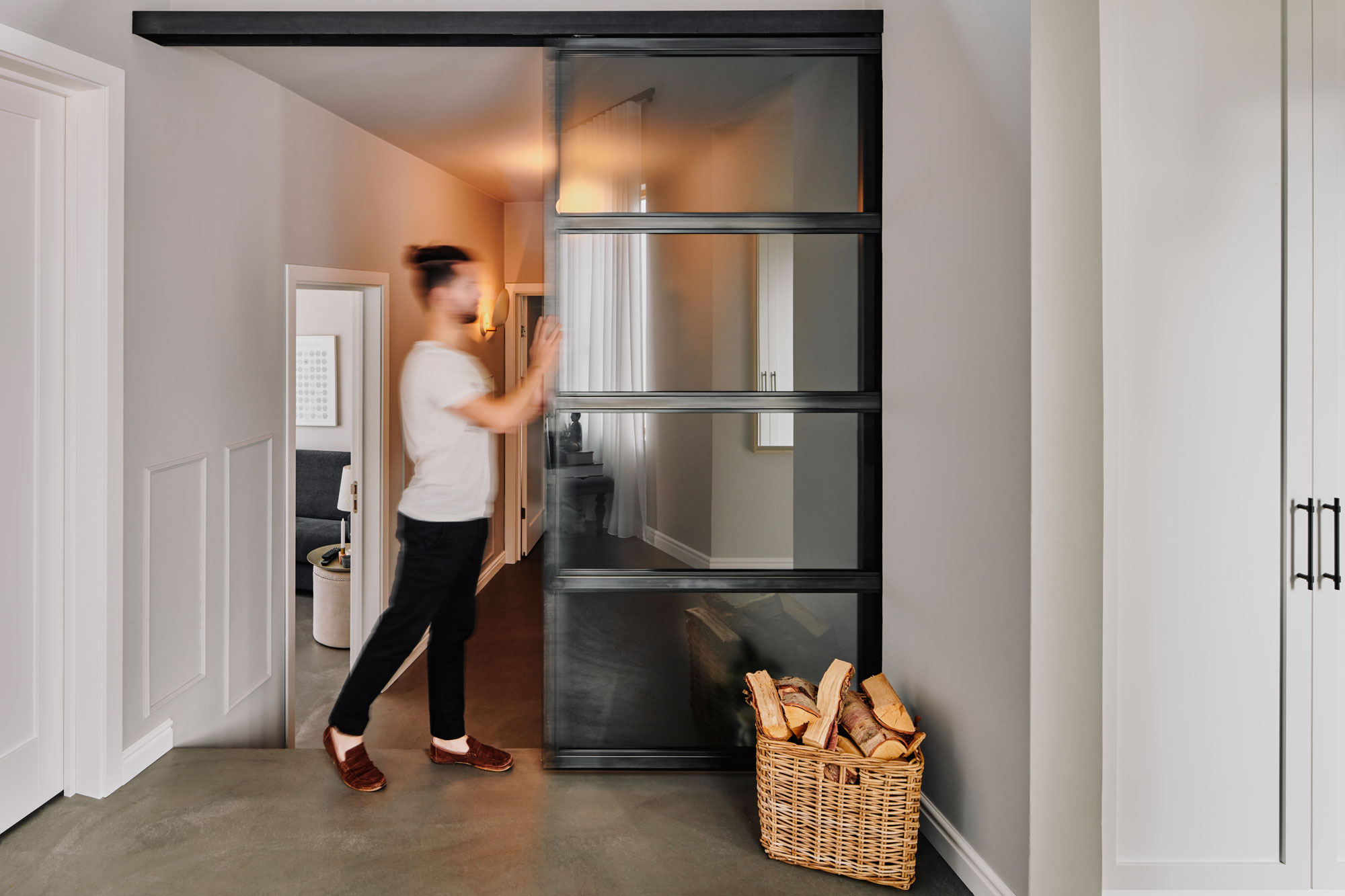 Blurred person closing railing door in japandi home