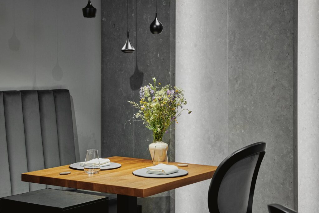 Restaurant wooden table with flowers and minimal lamps hanging