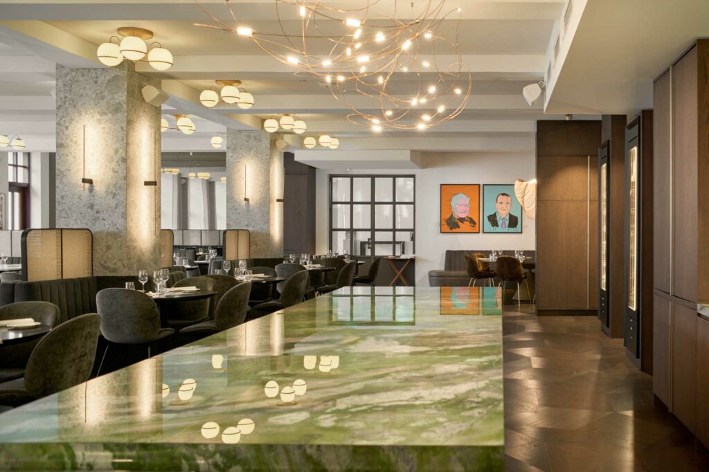 Contemporary restaurant with large green table and brown furniture
