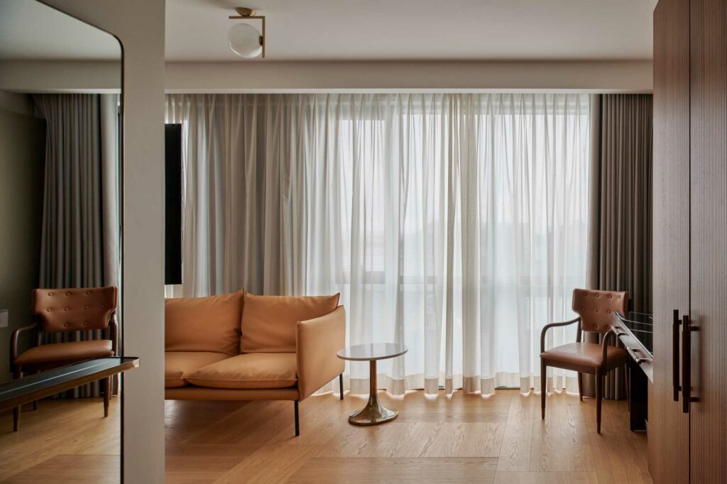 Room with minimal design yellow leather couch brown leather chair and wooden floor