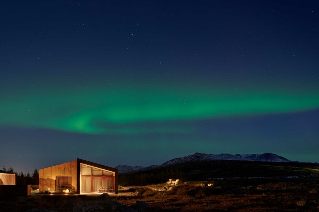 Family home at night time with northern lights in the sky