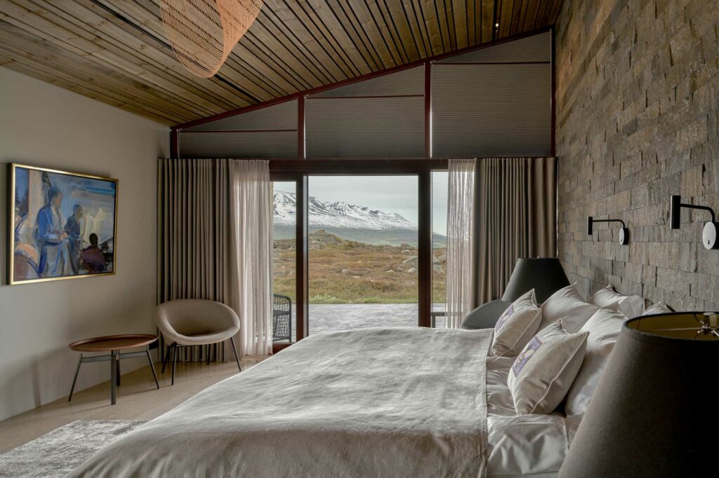Master bedroom with big bed and large window overlooking the mountain